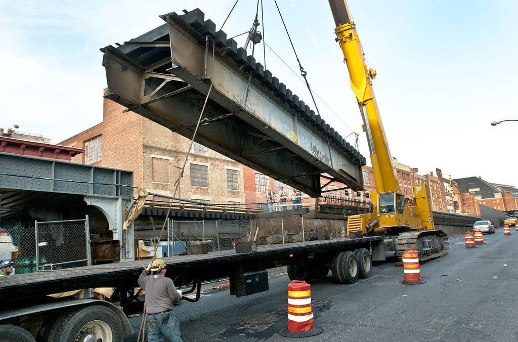 Flatbed trailer being loaded with a steel beam